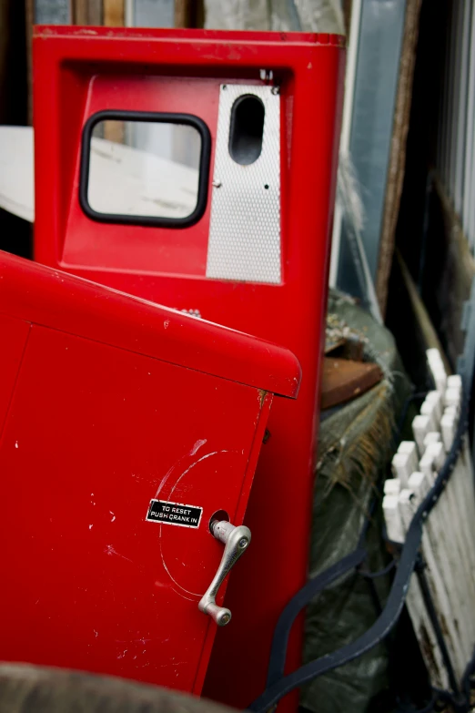 an old red box sitting outside a building