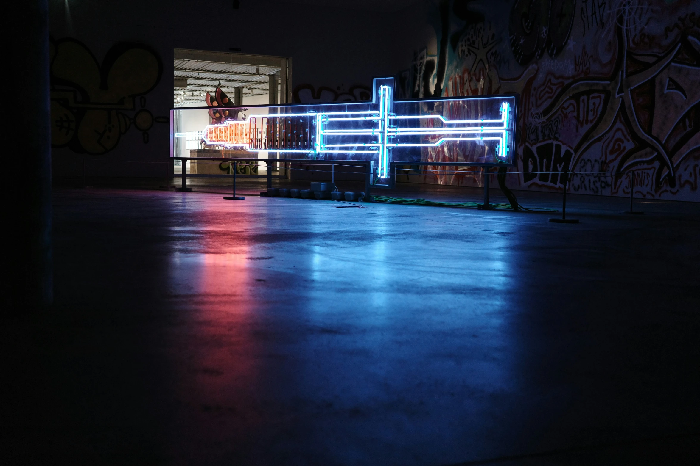 a neon lit fence in the middle of a street