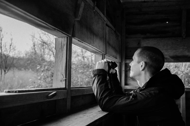a man holding soing while looking out a window