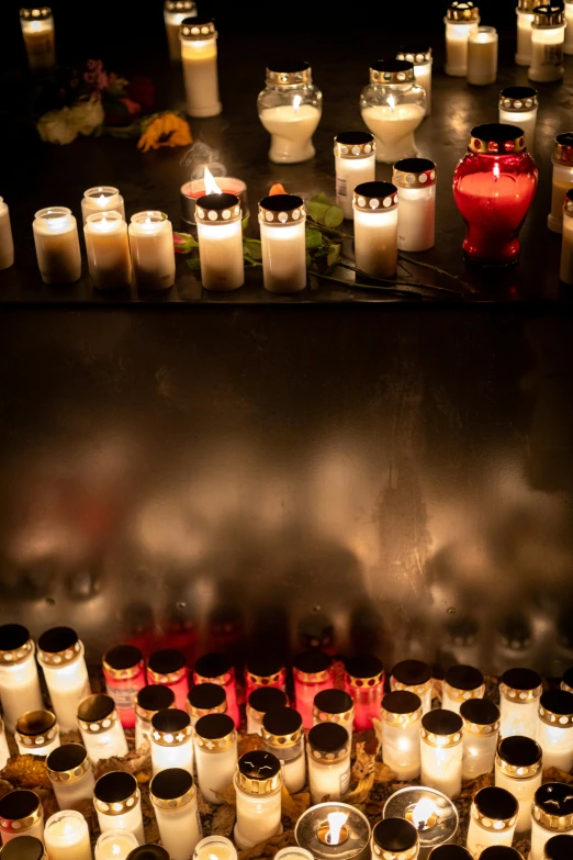 there are many white and black candles in front of each other