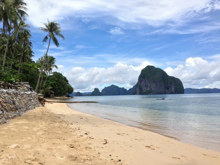 a sandy beach next to the ocean on a clear day