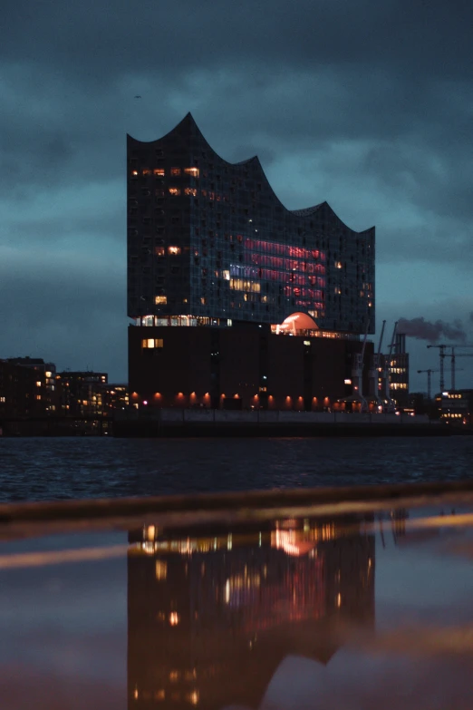 night po with large building behind the ocean