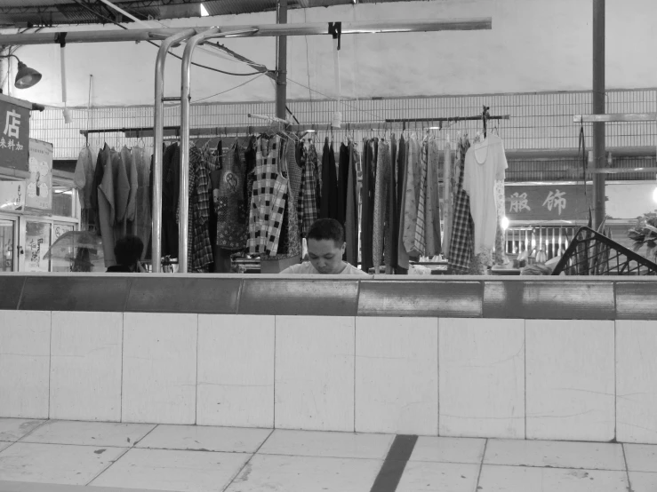 a man sits in front of an open market