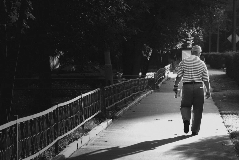 a man walking down a path towards a park