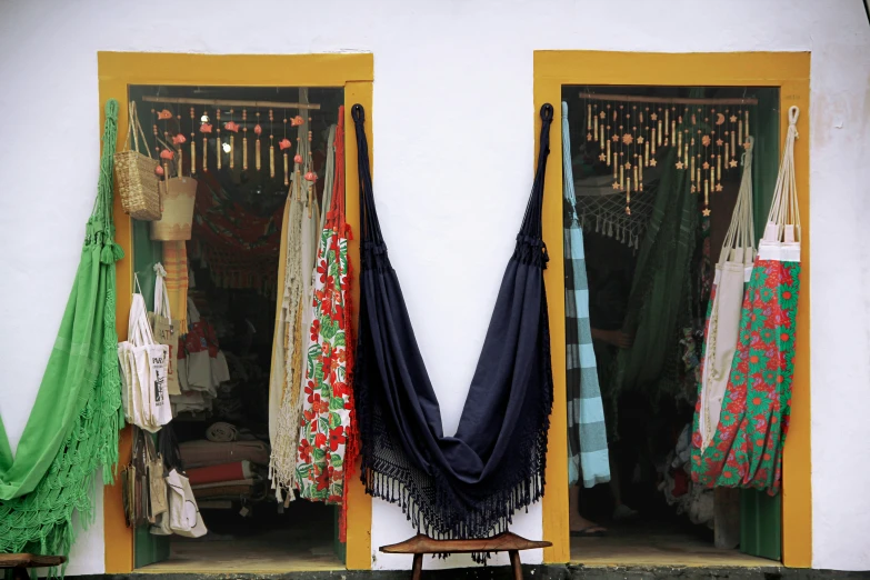 four open window frames with different colored scarves hanging in a store