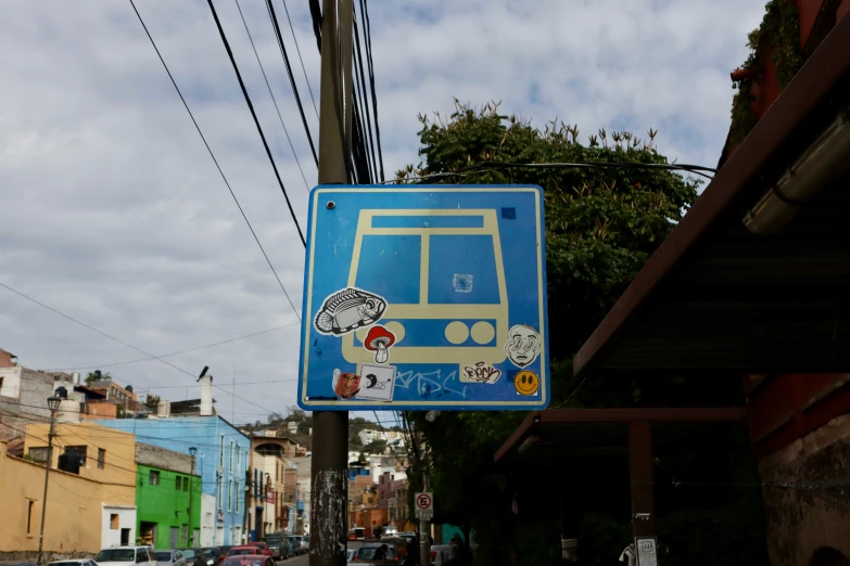 a blue street sign is shown with some stickers