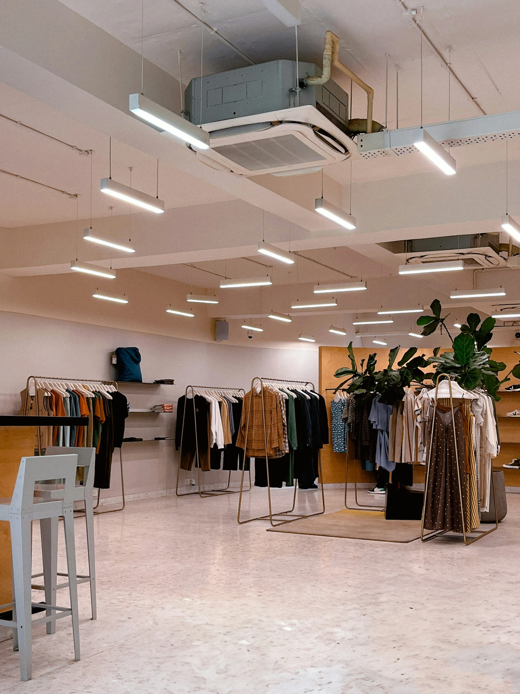 a retail store has several jackets and suits on the racks