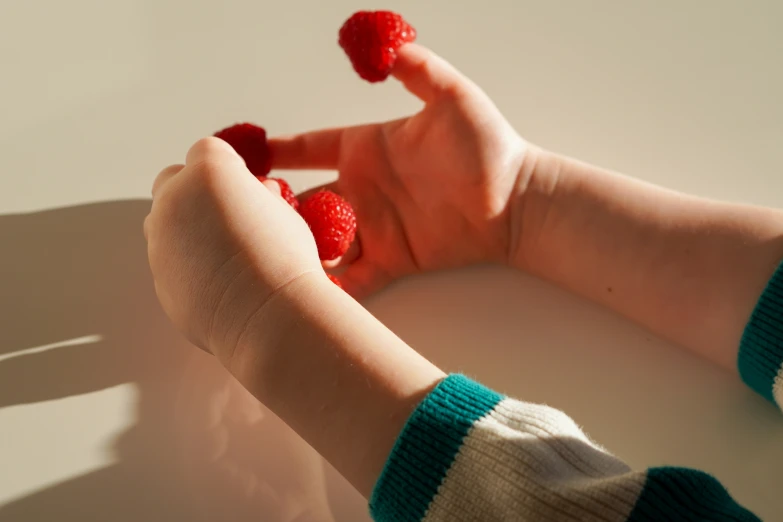 a person with raspberries in their hands