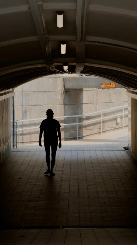 a person walking in an overpass with a bike on it