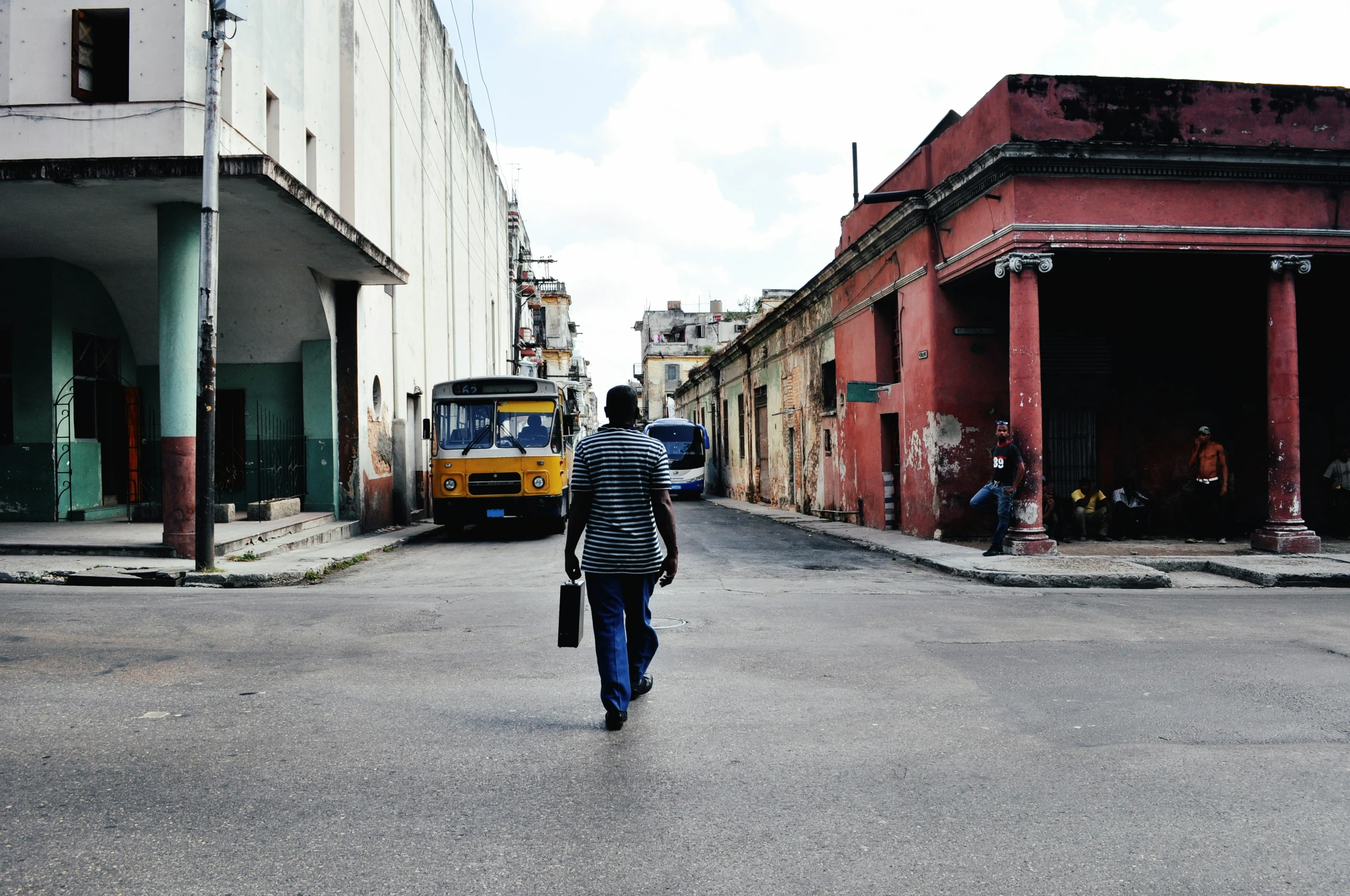 man on the street crossing the intersection, with traffic