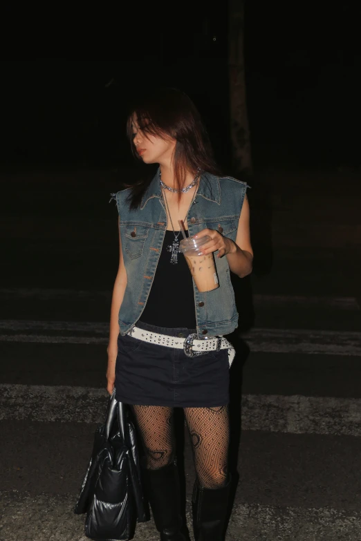 a woman standing on a street at night