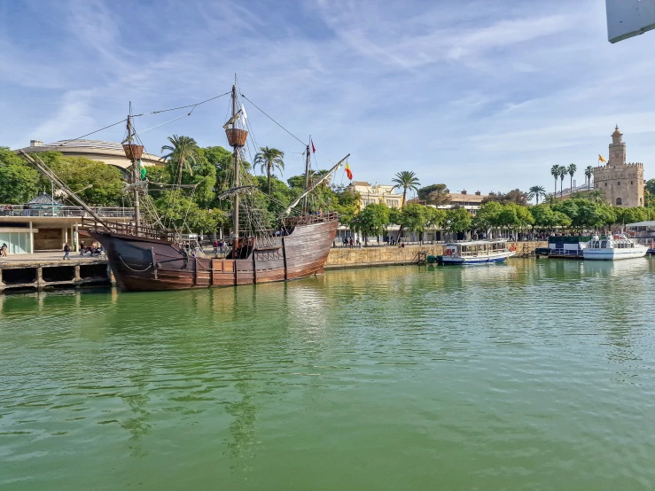 a large sailboat is sitting at the end of a dock