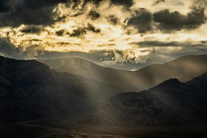 a few sun beams over some mountains