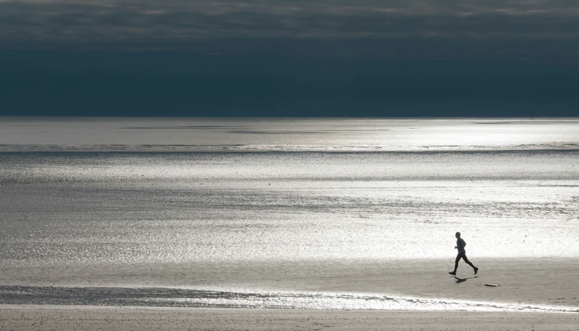 a person walking along a beach on the ocean