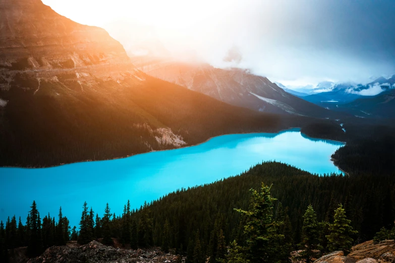 a blue lake in the mountains near some trees