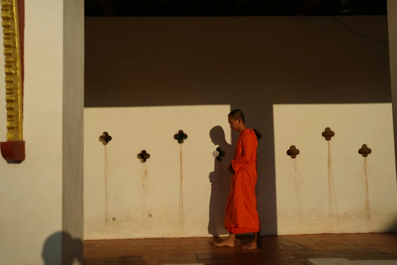 a monk walks down the side of a building