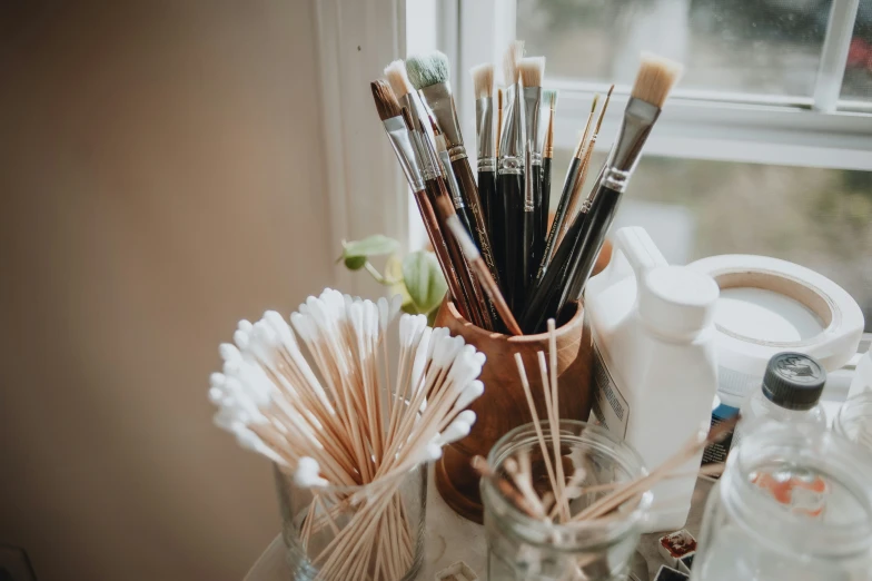 a collection of brushes in front of a window