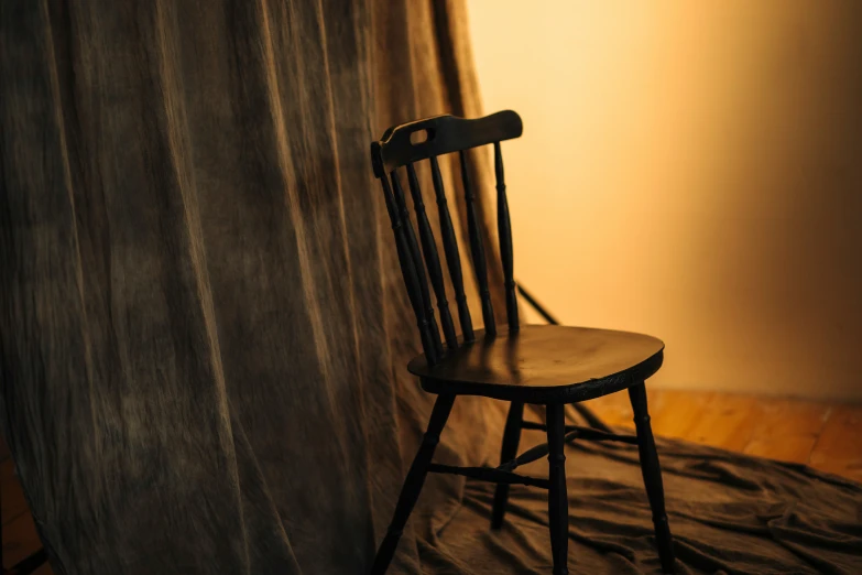 a chair sitting in front of a window next to a curtain