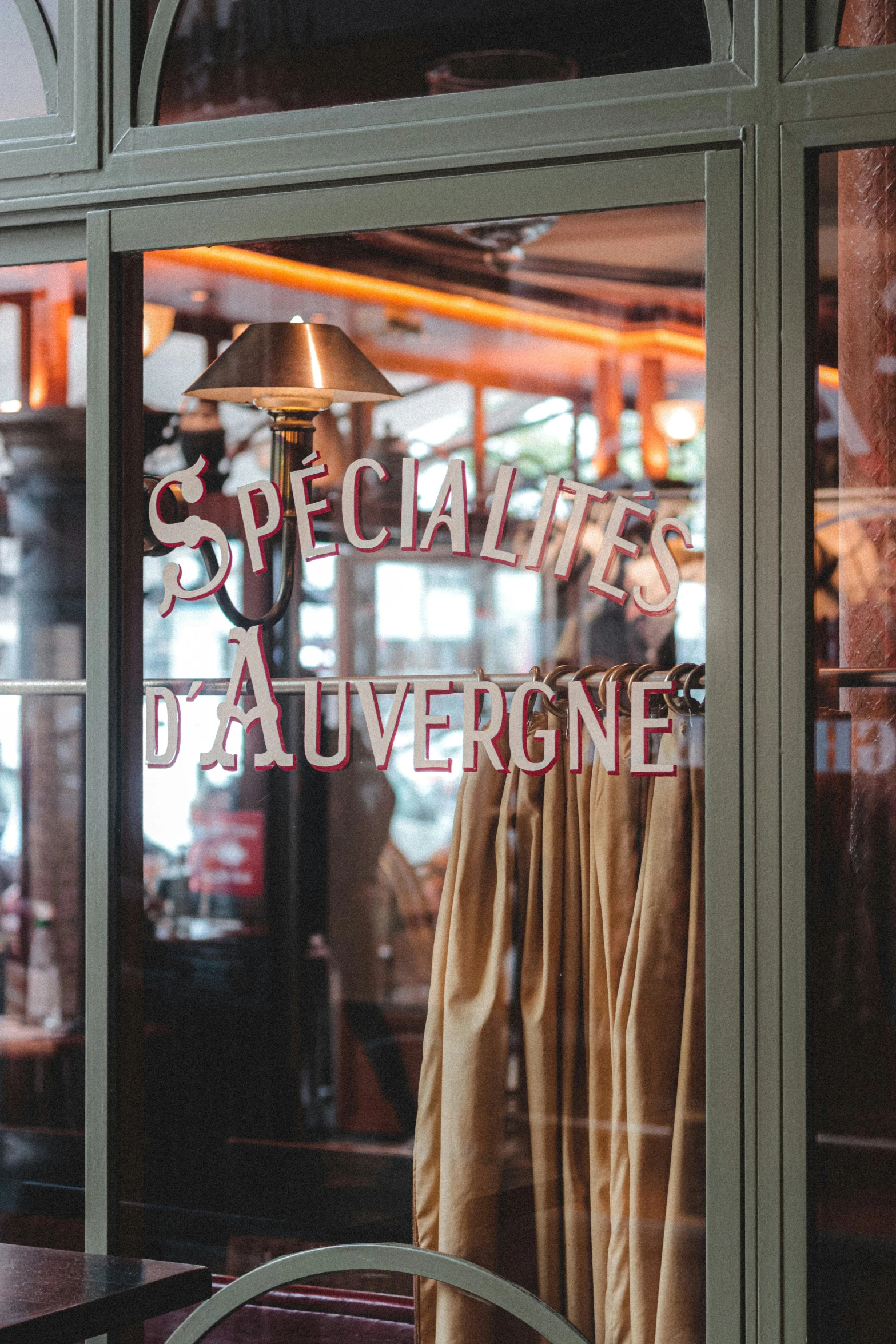 a cafe window with a coat hanging from it's side