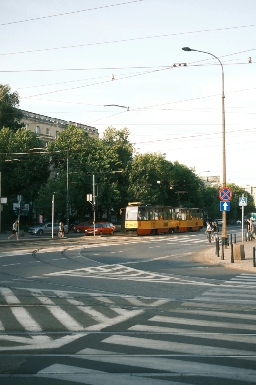 a train goes down the road with people crossing