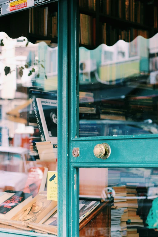 green painted door and shutters with a stack of books behind it