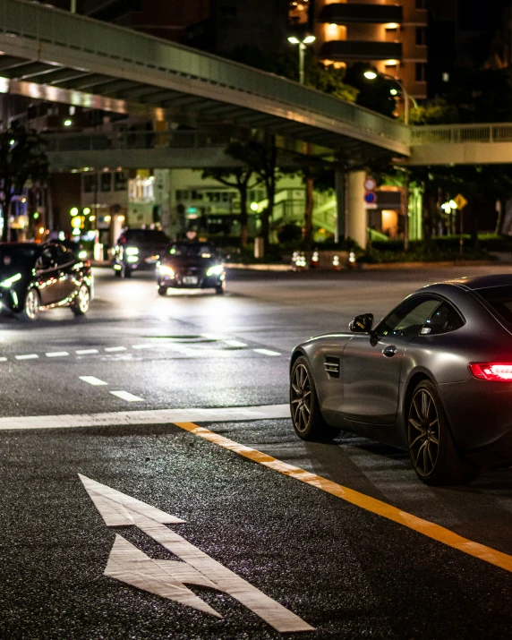 three cars are on the road during the night