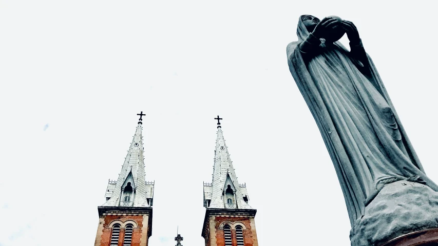 a statue of the person holding their arm up in front of two towers