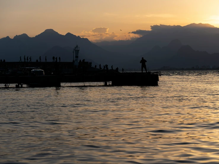 people on a pier on the edge of the water