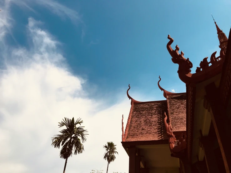 the architecture of an ancient building stands against a blue sky with many clouds