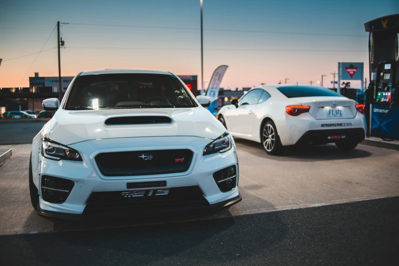 two white subaruent cars are on the street