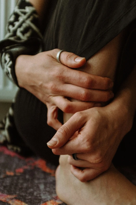 a woman sitting on top of a colorful floor holding her hands together