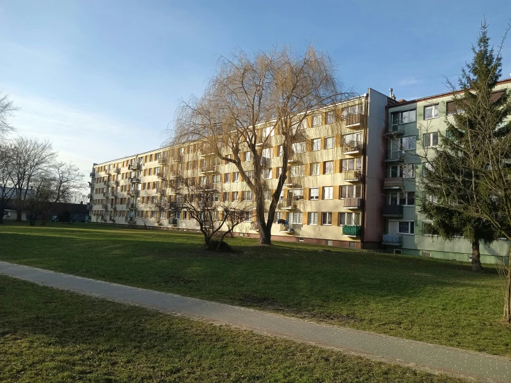 an apartment building near a green grass field