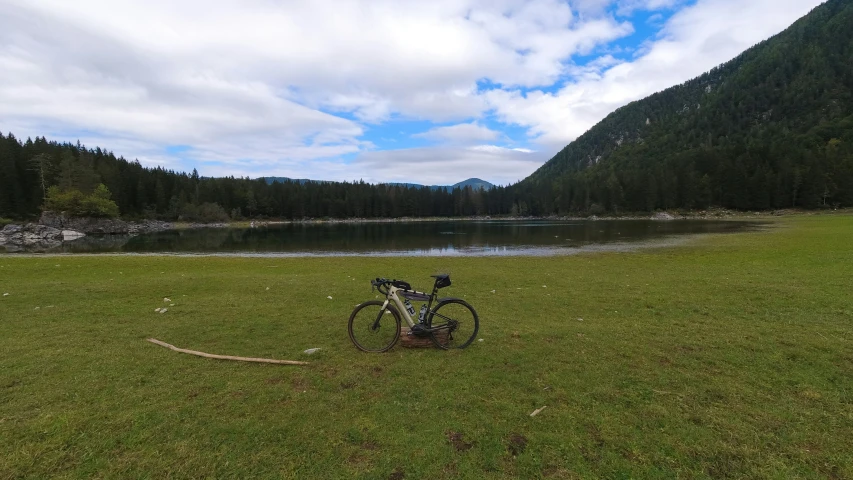 a bike sits on the grass near a lake