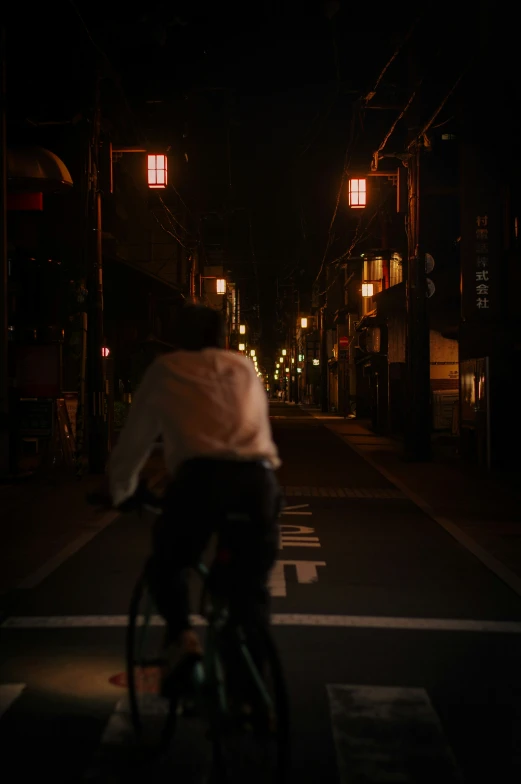 a man riding a bike at night on a street