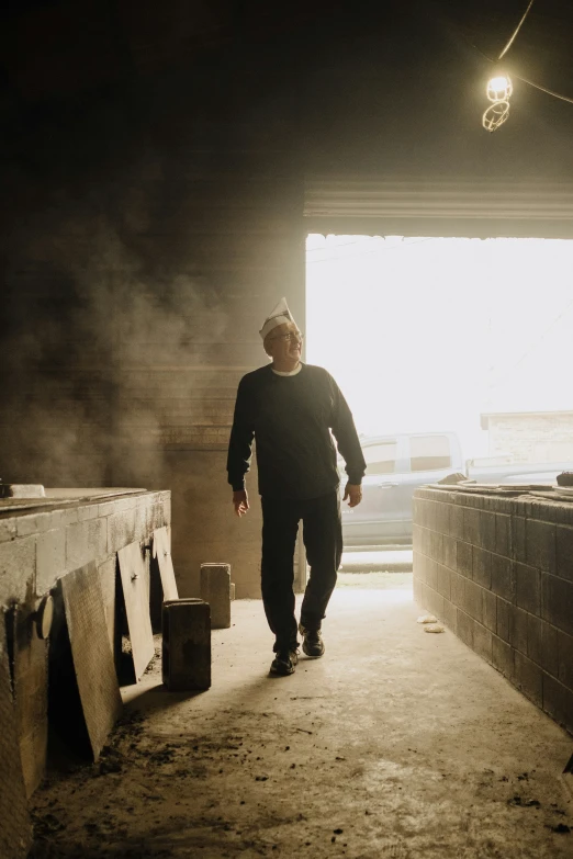 a man walking into a tunnel holding a crate