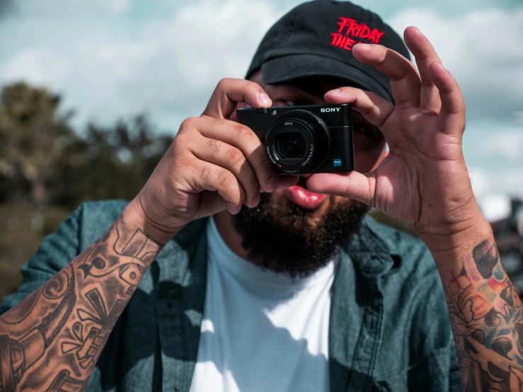 a man holding up a small camera and taking a po