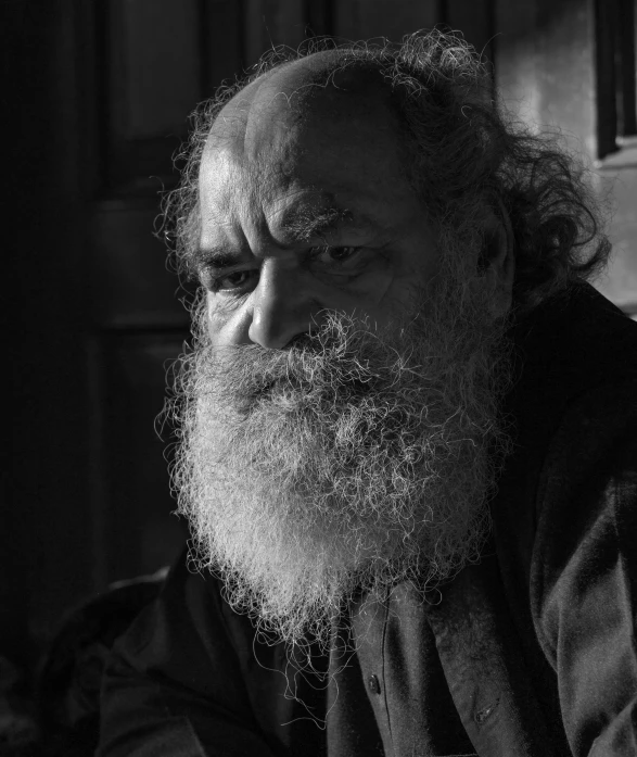 a black and white image of a man with long beard