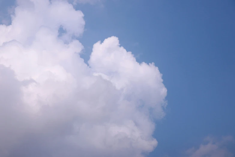 a plane is flying through the air on a cloudy day