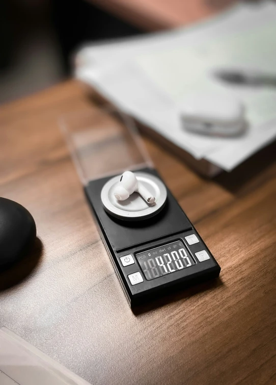 a clock sitting on a table near a computer mouse