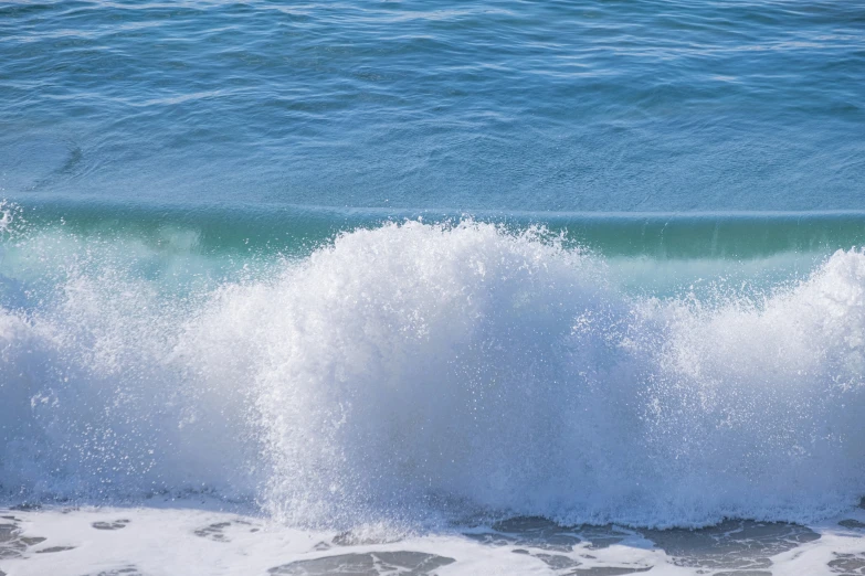 a wave is crashing into the shore of the ocean