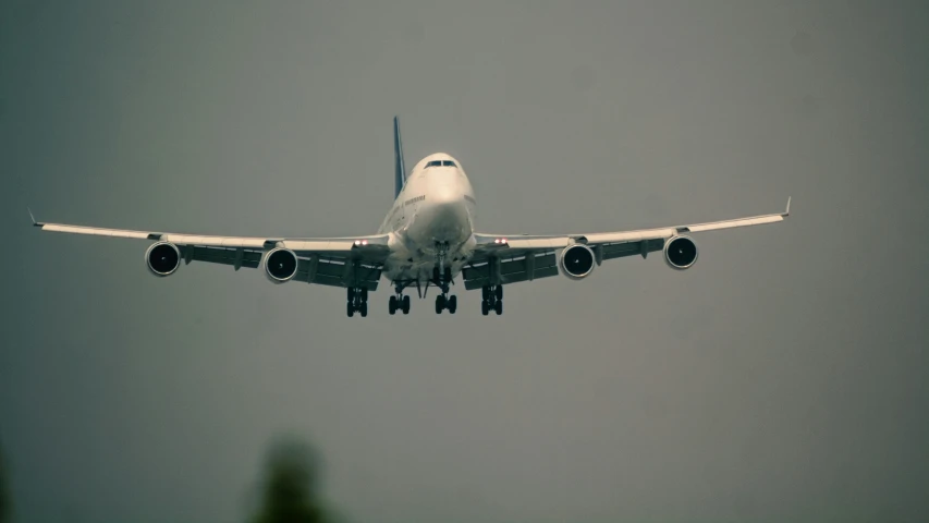 a large jetliner flying through a gray sky