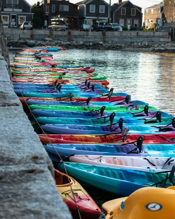 many rows of kayaks lined up next to the water