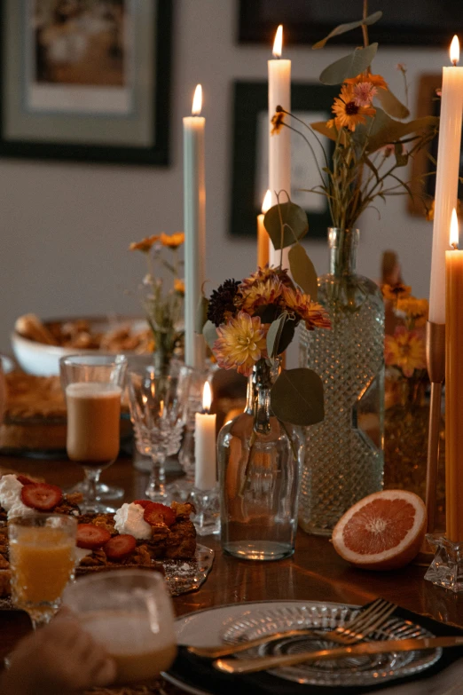 dinner table set up with food and candles