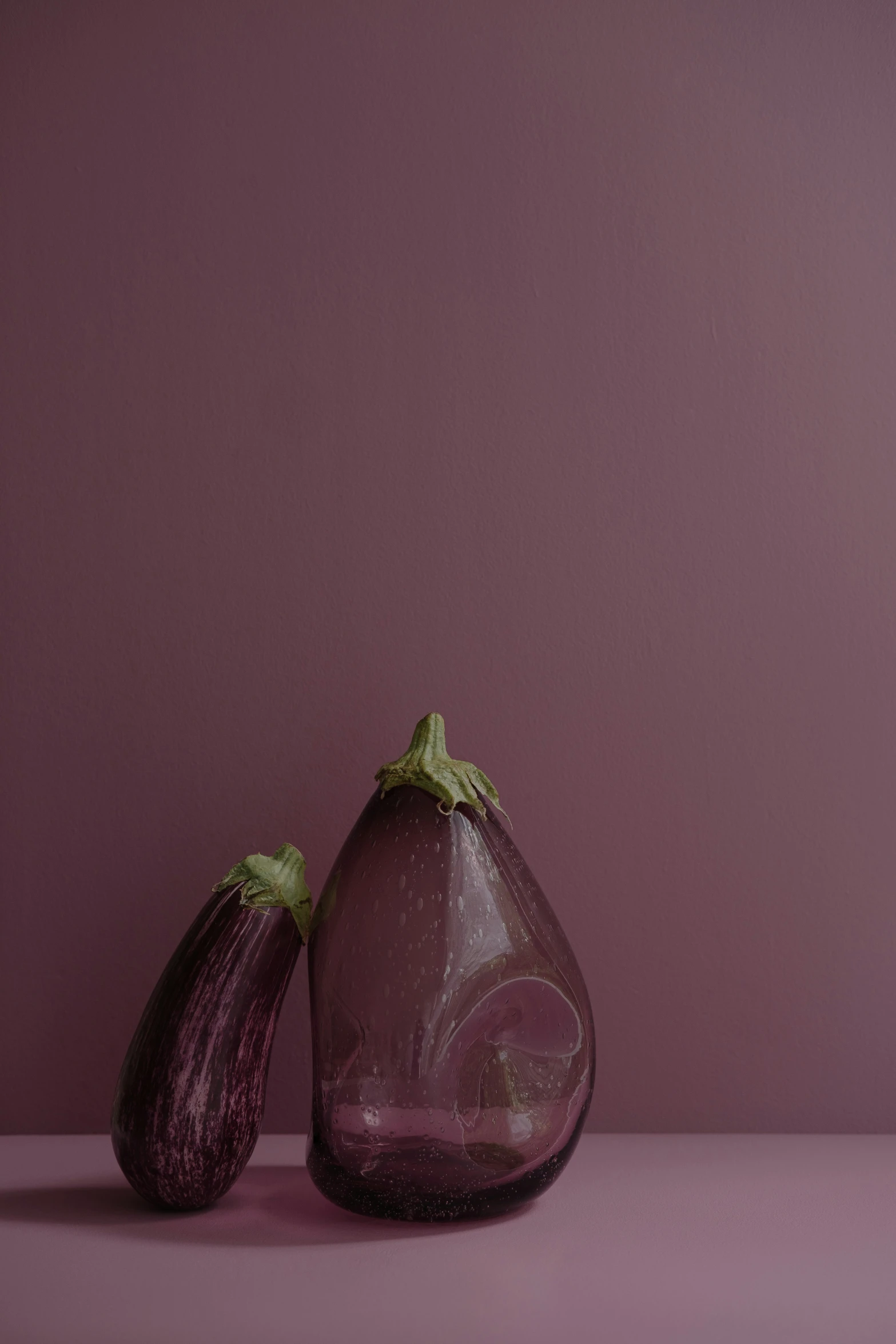 two small glass objects are on a purple background