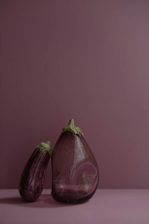 two small glass objects are on a purple background