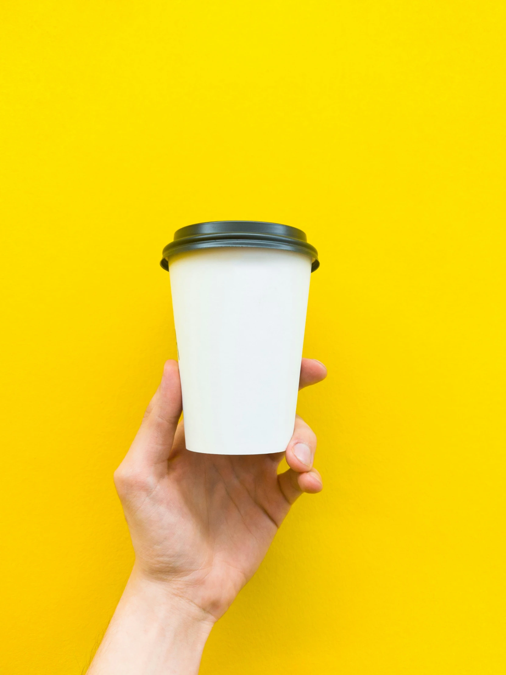 the hand holds up the top of a cup