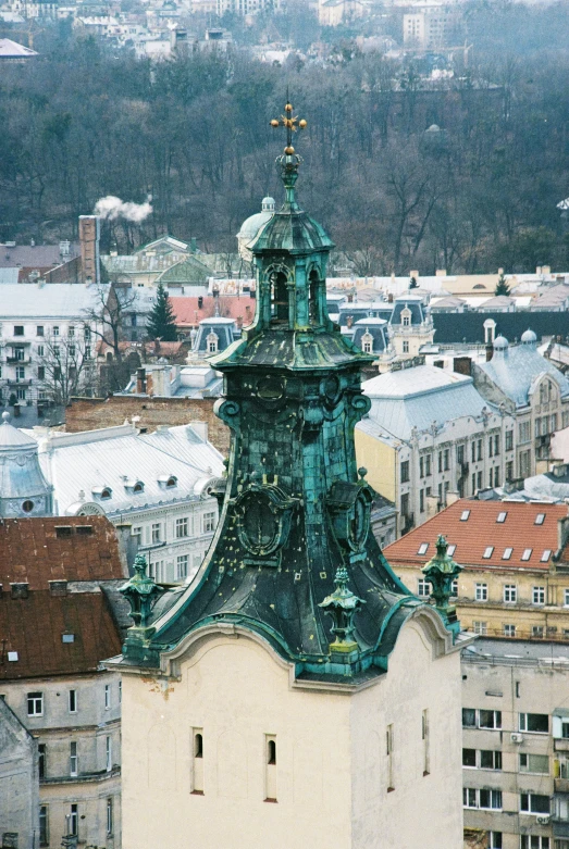 a large green clock tower above an ornate city