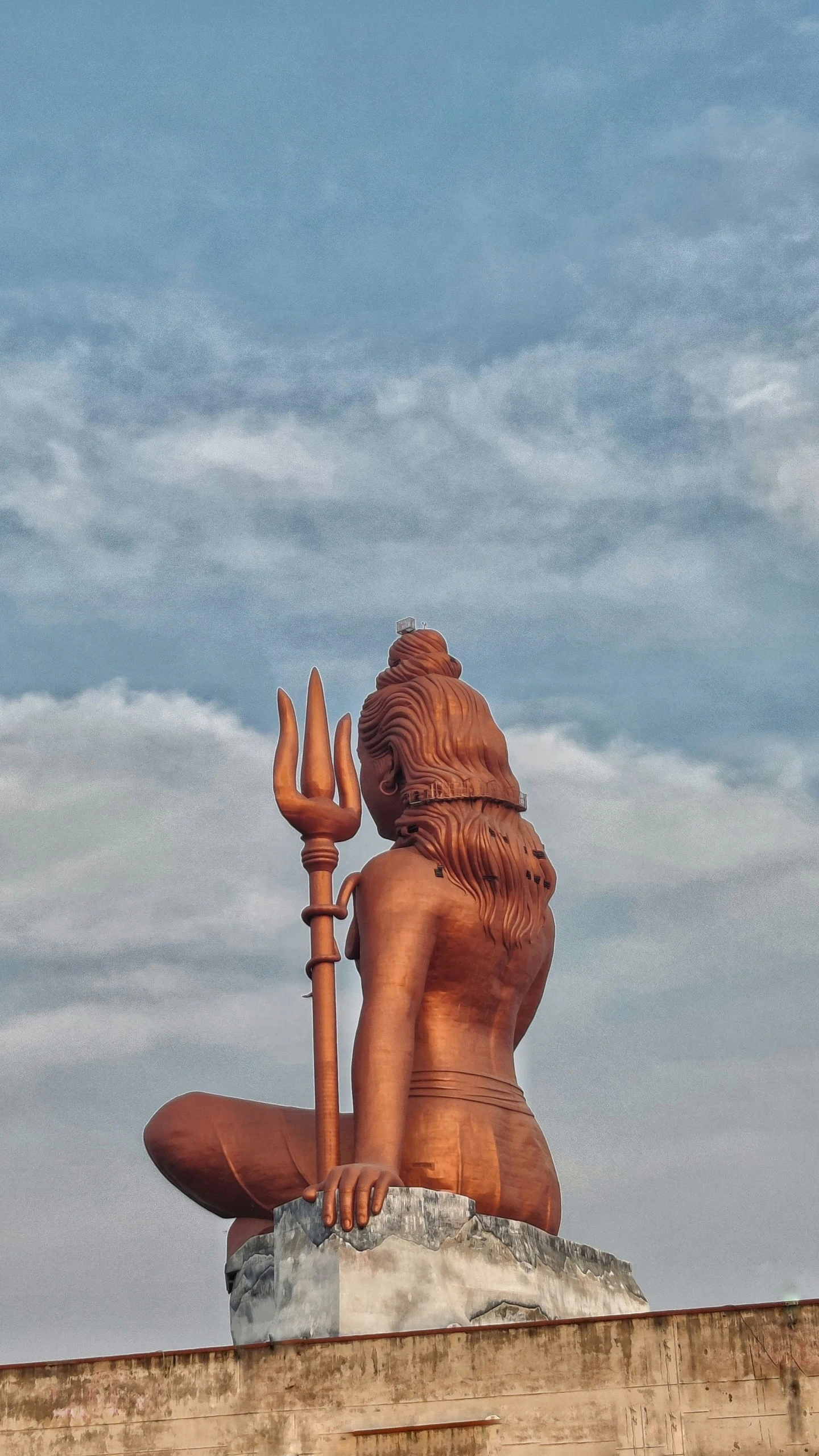 statue of the god sitting on the roof of a house