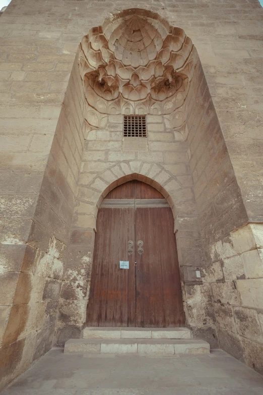 a large brick structure with doors and window at the entrance