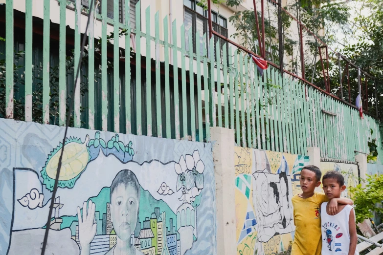 two people that are standing by some graffiti